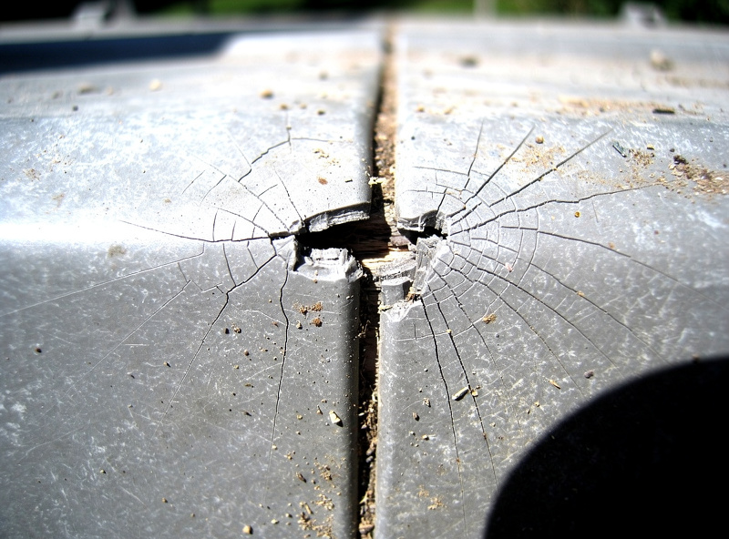 Close-up of UV stress cracking on the seam of an aged plastic chicken coop panel