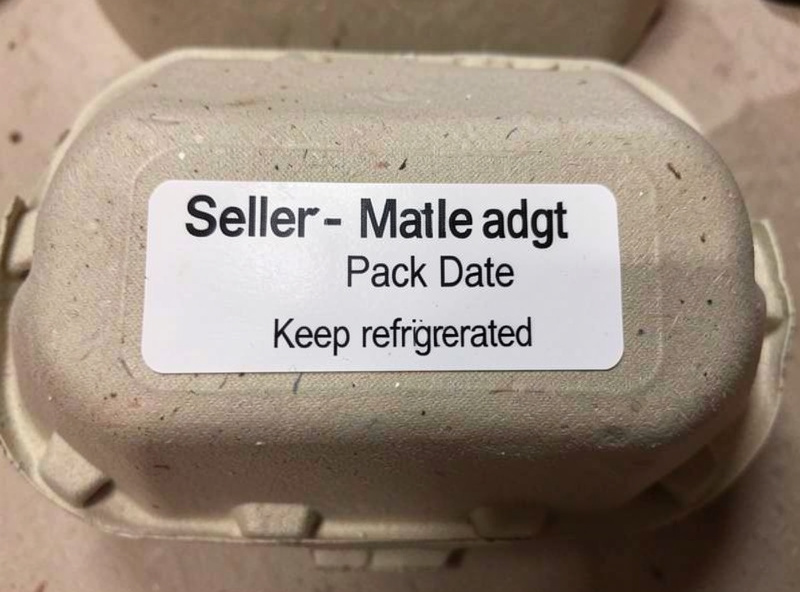 Close-up of a compliant egg carton label showing seller name, pack date and keep refrigerated note