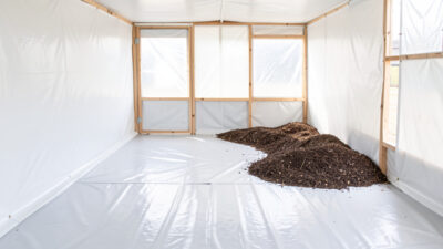 Chicken coop interior with a seamless sheet-vinyl floor coved up the walls
